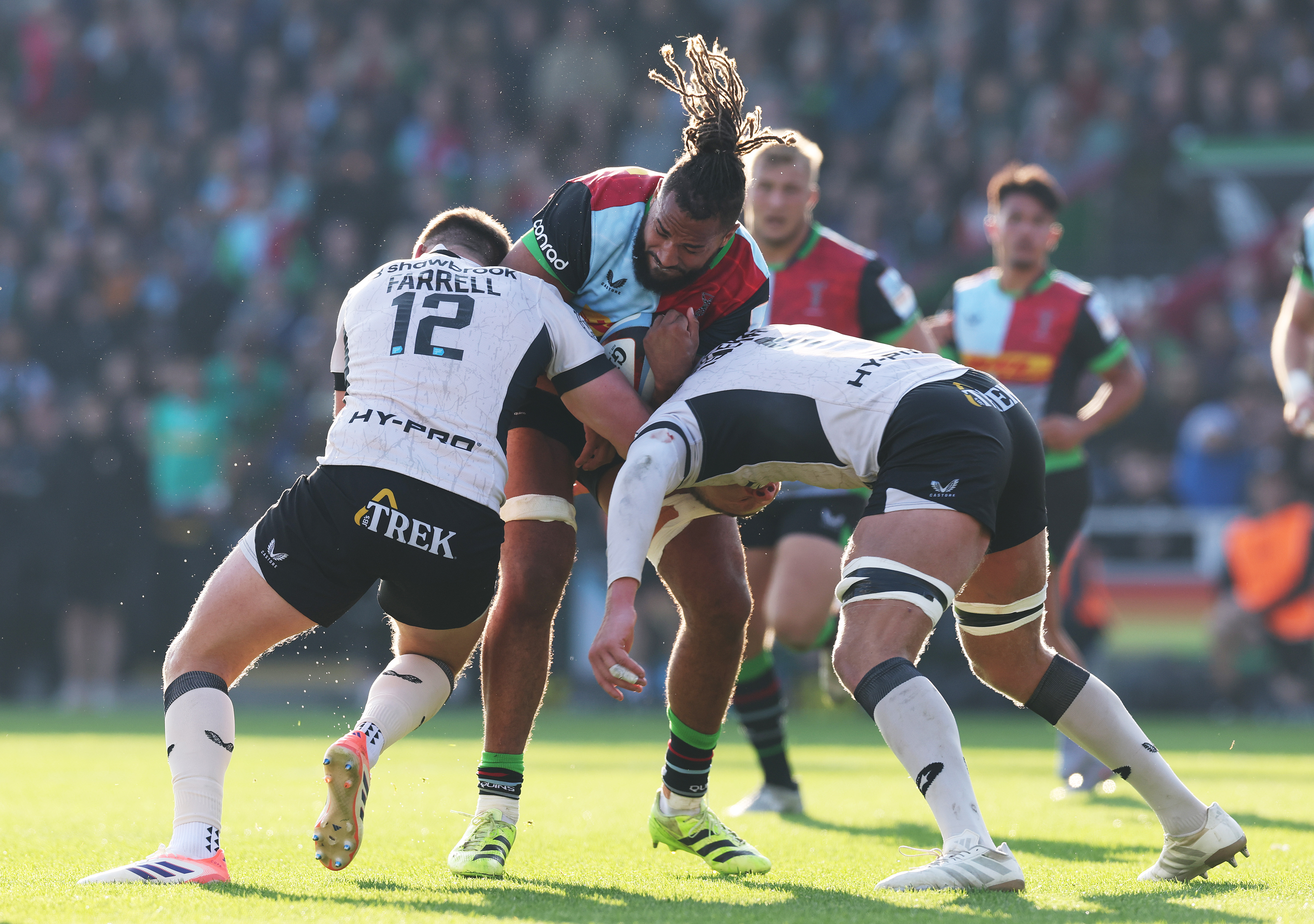 Chandler Cunningham-South of Harlequins is tackled by Owen Farrell and Nick Isiekwe of Saracens during the Gallagher PREM match.