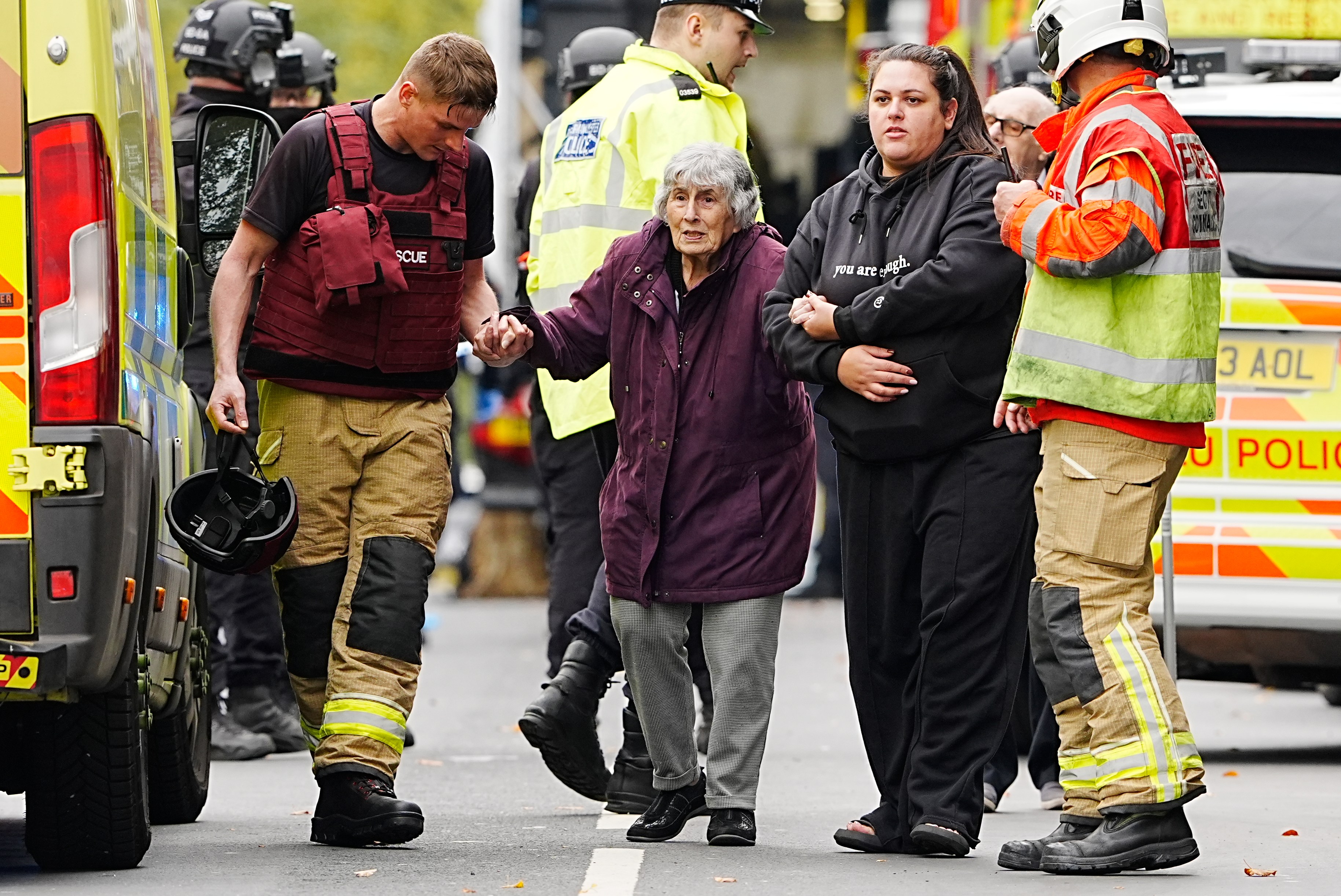 A member of the public is helped from the scene by emergency services
