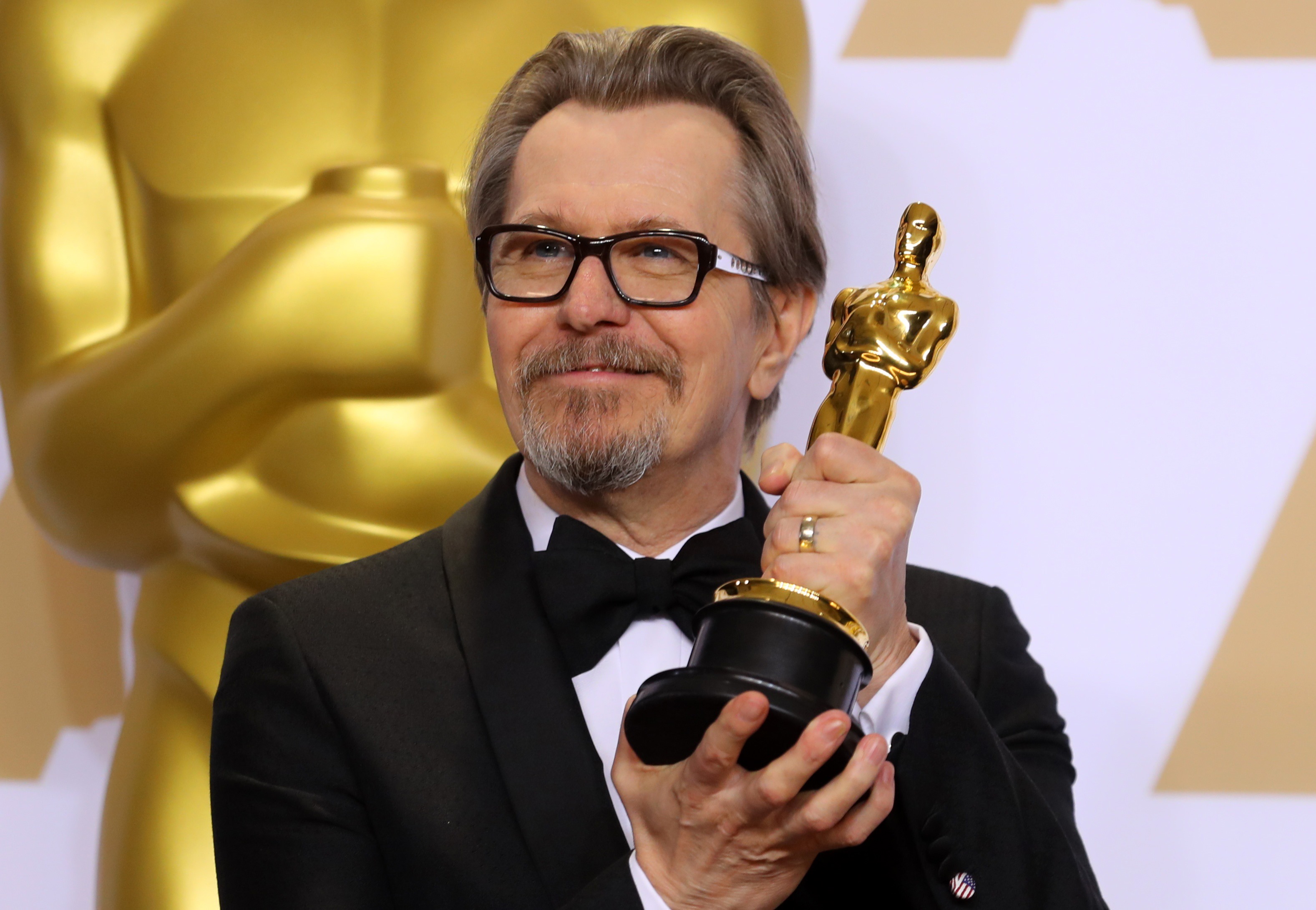 Gary Oldman holds his Oscar award.