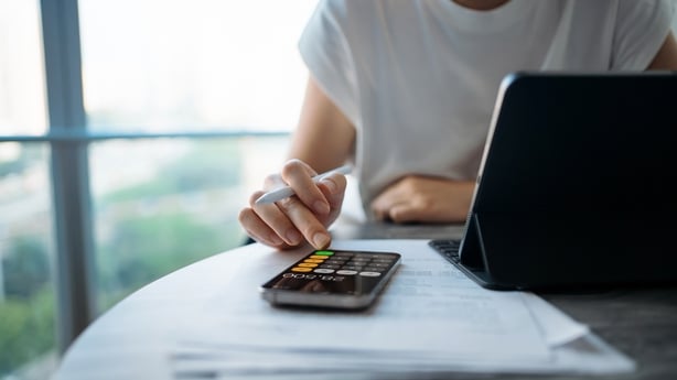 a woman using a calculator to manage her personal banking