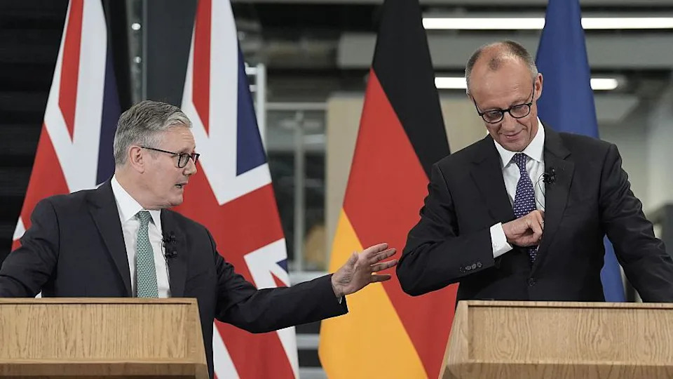 Keir Starmer (L) and Germany's Chancellor Friedrich Merz (R) make remarks as they visit the Airbus facility in Stevenage, southern England, on July 17, 2025