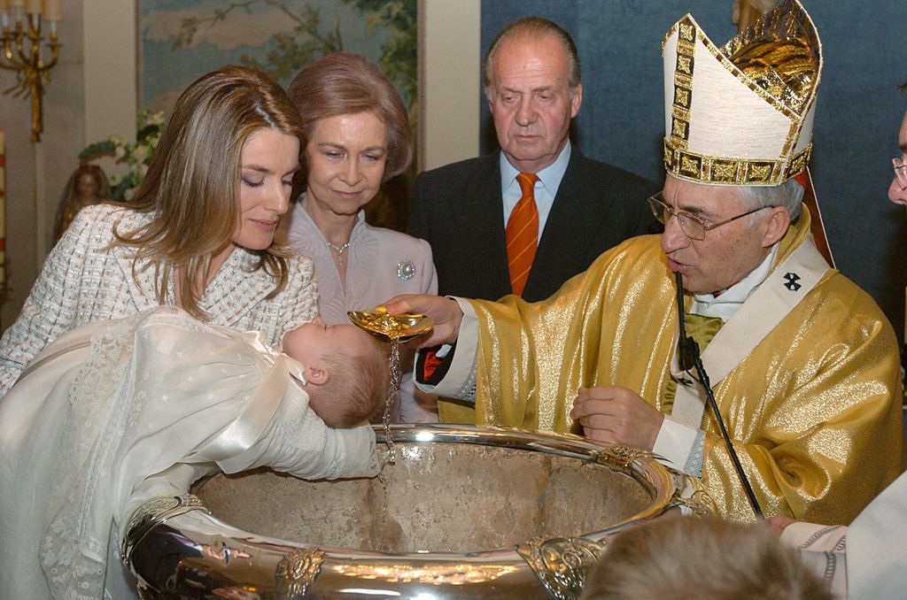 MADRID, Spain:  Spain's Princess Letizia (L) holds her daughter Leonor as Cardinal Antonio Maria Rouco Varela (R) baptises the child with water from the river Jordan while Spain's Queen Sofia and King Juan Carlos look on at the Zarzuela Palace in Madrid, 14 January 2006.    AFP PHOTO/POOL//Angel Diaz  (Photo credit should read ANGEL DIAZ/AFP via Getty Images)