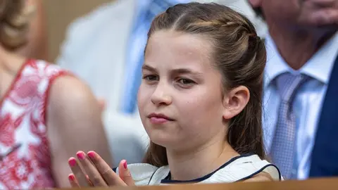Getty Images Princess Charlotte ina  white dress sits among others
