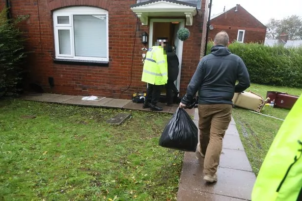 Officers, and officials thought to be counter-terror police, search a property in Farnworth