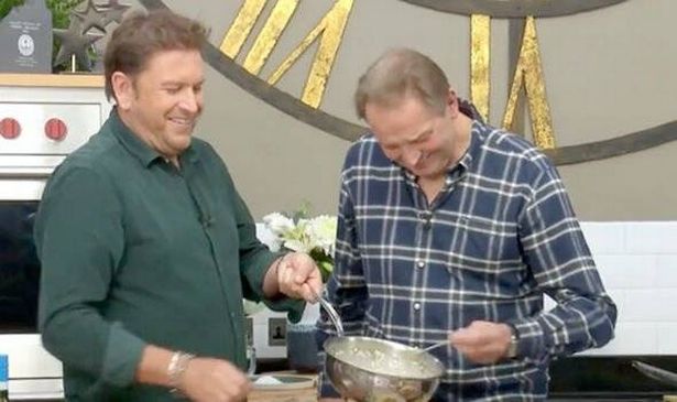 A man in green and a man in blue laugh