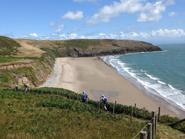 Walkers on the Wales Coast Path above Porth Ceiriad beach on the Llŷn Peninsula