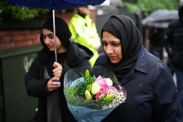 Wellwishers leave flowers at the scene