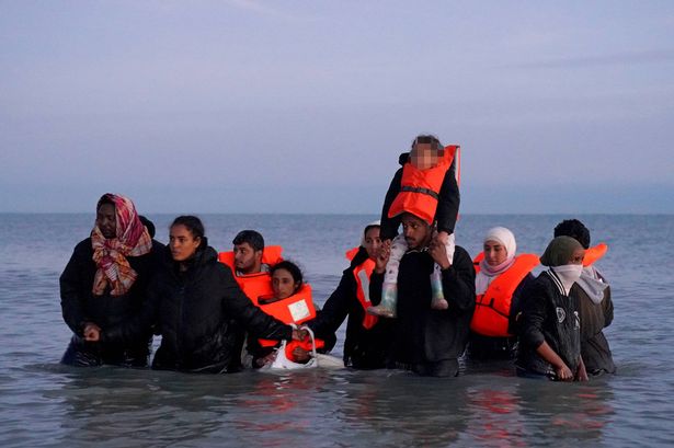 EDITORS NOTE: Children's faces have been pixelated as the PA Picture Desk has been unable to gain the necessary permission to photograph a child under 16 on issues involving their welfare. A group of people thought to be migrants wade into the sea to meet a small boat in Gravelines, France. Picture date: Friday September 19, 2025.