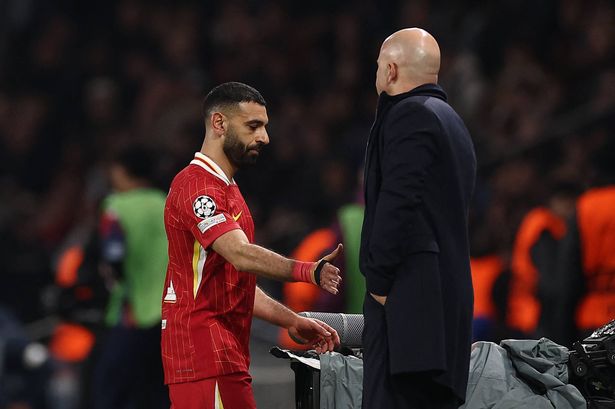 Liverpool's Egyptian forward #11 Mohamed Salah (L) shakes hands with Liverpool's Dutch coach Arne Slot (R) as he is substituted during the UEFA Champions League Round of 16 first leg football match between Paris Saint-Germain (FRA) and Liverpool (ENG) at the Parc des Princes stadium in Paris on March 5, 2025. (Photo by FRANCK FIFE / AFP) (Photo by FRANCK FIFE/AFP via Getty Images)