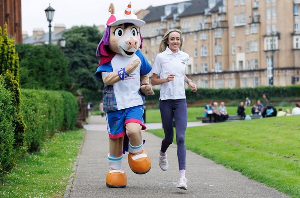Finnie the mascot running with Scottish medal hopeful Eilish McColgan