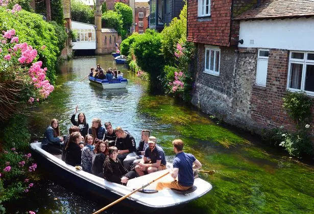 Punts with teenagers on holiday, enjoying a tour on the River Stour, in Canterbury, England.