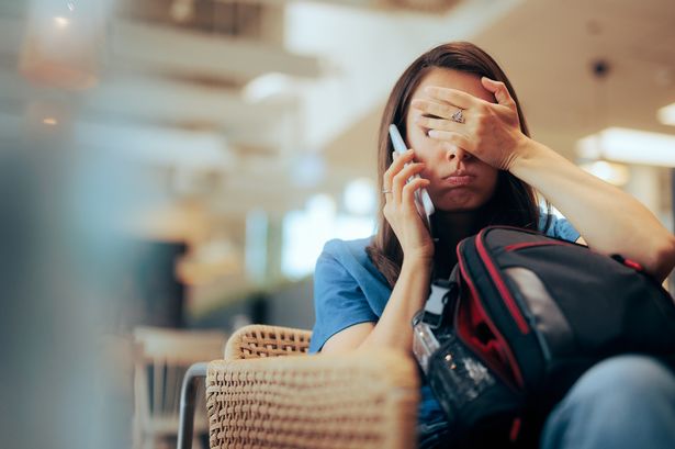Stressed traveler speaking on her mobile phone after being delayed