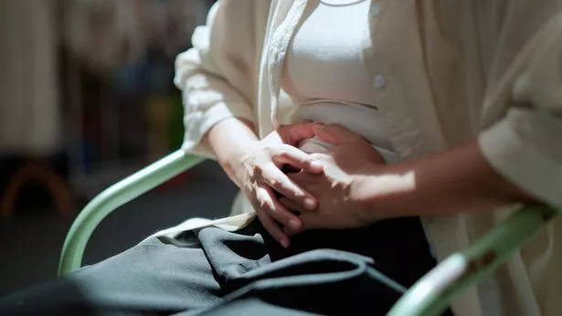 Woman sat down with stomach pain