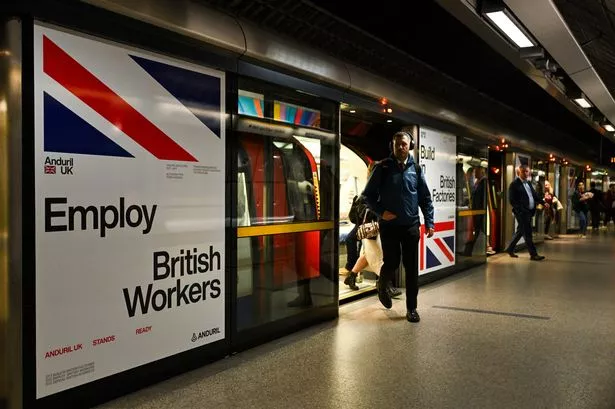 A man getting off a Tube train at a station
