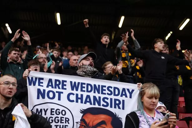 LONDON, ENGLAND - OCTOBER 18: A fan of Sheffield Wednesday holds a protest banner depicting the image of Dejphon Chansiri, owner of Sheffield Wednesday, following the team's defeat in the Sky Bet Championship match between Charlton Athletic and Sheffield Wednesday at The Valley on October 18, 2025 in London, England. (Photo by James Fearn/Getty Images)