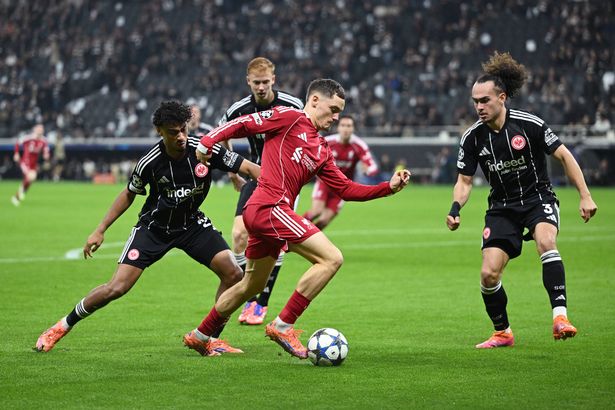 Florian Wirtz of Liverpool runs with the ball from Arthur Theate of Eintracht Frankfurt during the UEFA Champions League