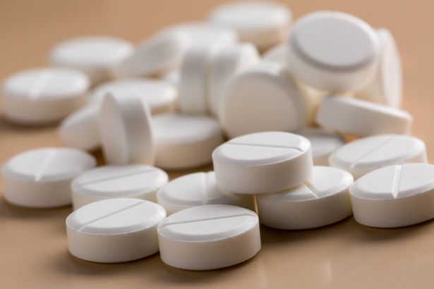 Heap of round white pills pn beige background