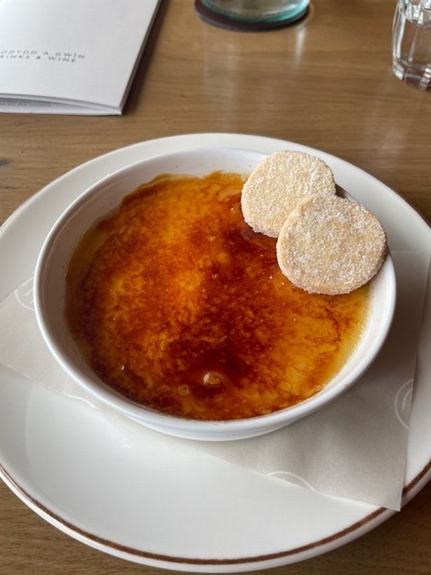 A bay leaf crème brulee with two pieces of shortbread