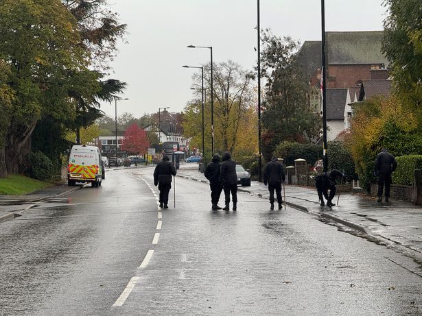 Police officers dressed all in black and from West Midlands Police's Operational Support Unit carried out a careful search along Birmingham Road in Wylde Green, Sutton Coldfield, looking for clues following a shooting