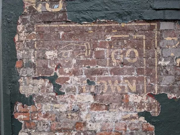 A ghost sign uncovered at the Pig & Whistle in Liverpool city centre, signalling to the lost shop beneath the building