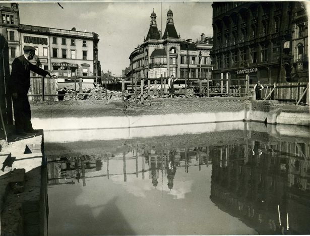 One of the emergency static water supply reservoirs constructed in Liverpool during the Blitz. The water is contained in the basement of a building destroyed by a bombing raid. The picture shows Cooper's and Bunney's shops, at the corner of Church Street and Whitechapel