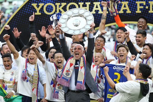 Kevin Muscat (C) holds up the trophy as he celebrates  after taking Japan's professional J-League football title
