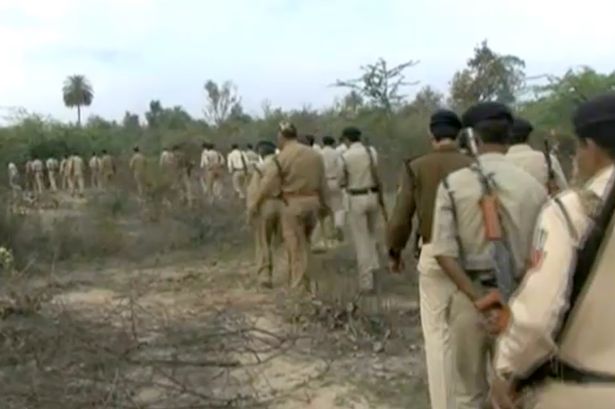 Indian police officers walking in field