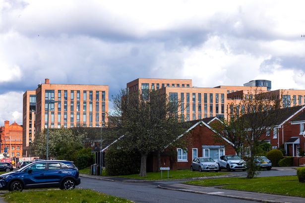 New apartment blocks tower over houses on the low-rise housing estate