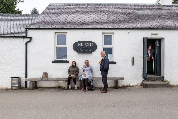 Inverie, Scotland Jul 24 2025 Drinkers outside the Old Forge pub on the Knoydart Peninsula. The remotest pub in the UK, this community-owned bar is a unique travel destination only accessible by boat or long hike