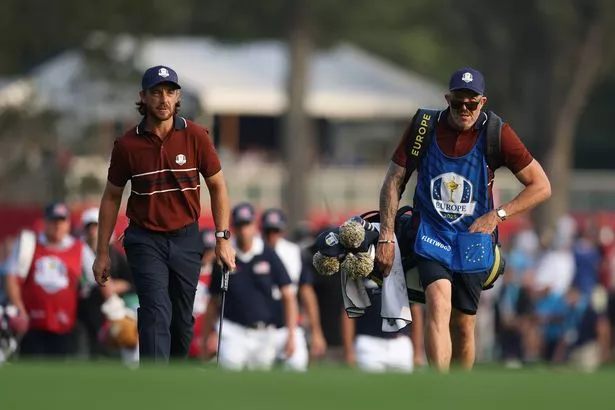 Tommy Fleetwood of Team Europe and his caddie Ian Finnis walk to the third hole during the Saturday morning foursomes matches of the 2025 Ryder Cup at Black Course at Bethpage State Park Golf Course on September 27, 2025 in Farmingdale, New York.