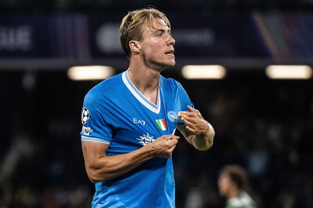 Rasmus Hojlund points at the Napoli badge.