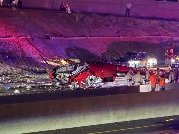 Law enforcement officers stand near the wreckage of a helicopter that crashed on eastbound Highway 50 in Sacramento, Calif., Monday, Oct. 6, 2025. (Robert Petersen via AP)