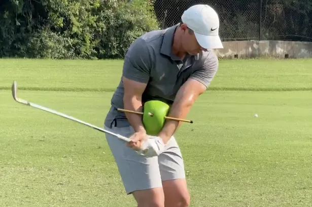 Rory McIlroy on the range in India with a training aid