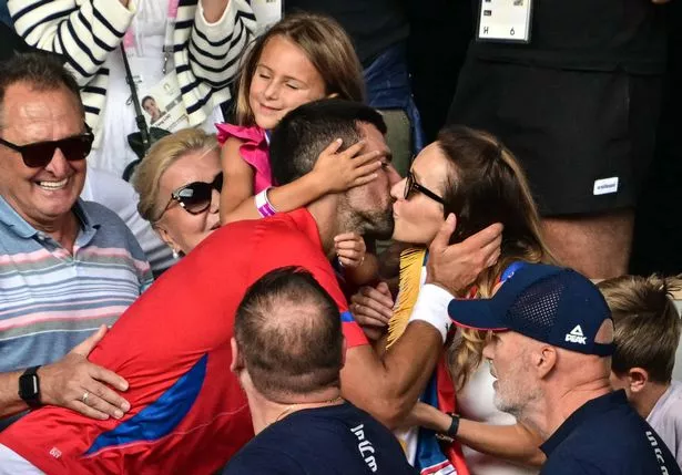 Serbia's Novak Djokovic gives his wife Jelena a kiss as he celebrates with his family in the crowd after beating Spain's Carlos Alcaraz in their men's singles final tennis match on Court Philippe-Chatrier at the Roland-Garros Stadium during the Paris 2024 Olympic Games, in Paris on August 4, 2024.
