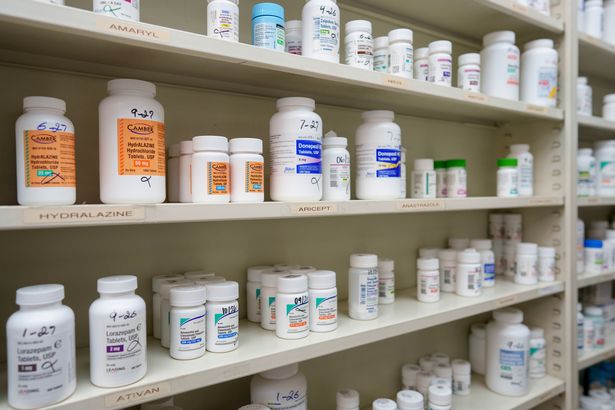 Medications are stored on shelves at a pharmacy 