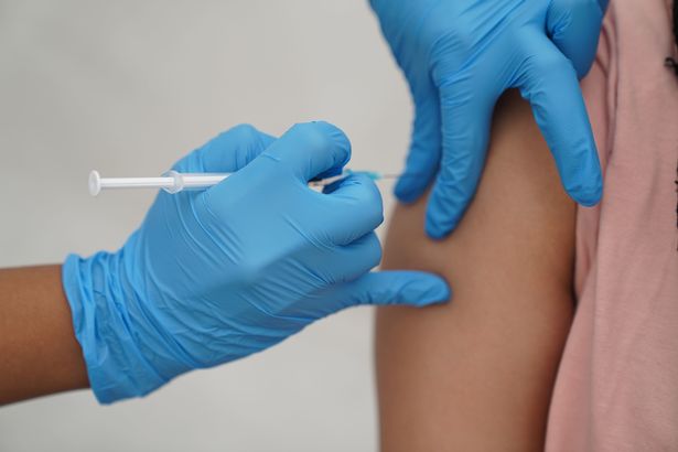 a person receiving a Covid-19 jab