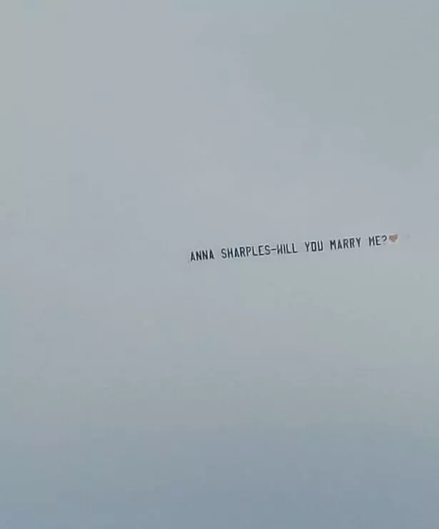 A banner in the sky over Crosby reads: 'Anna Sharples - will you marry me?'