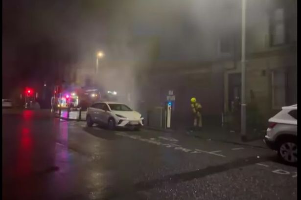 Firefighter standing outside shop on fire in Glasgow's southside