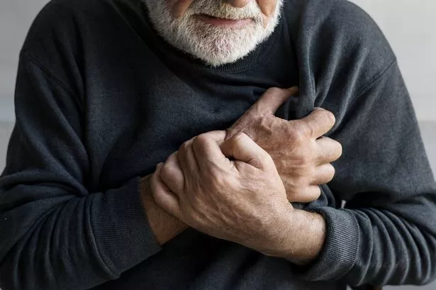 A man clutches his chest in pain