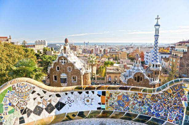 A view across Barcelona from the colourful mosaic tiled walls of Park Guell.