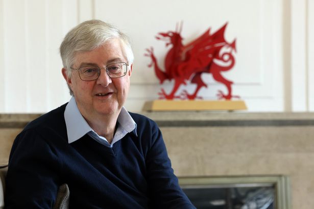 Man in jumper in front of red dragon ornament