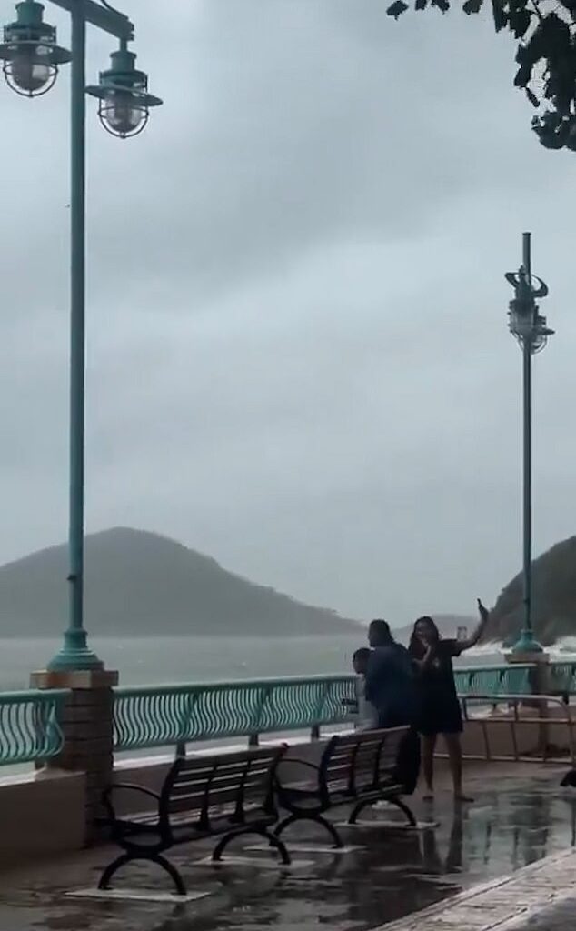 This is the terrifying moment two women and a child were swept aside by powerful sea waves as they posed for photos during Typhoon Ragasa