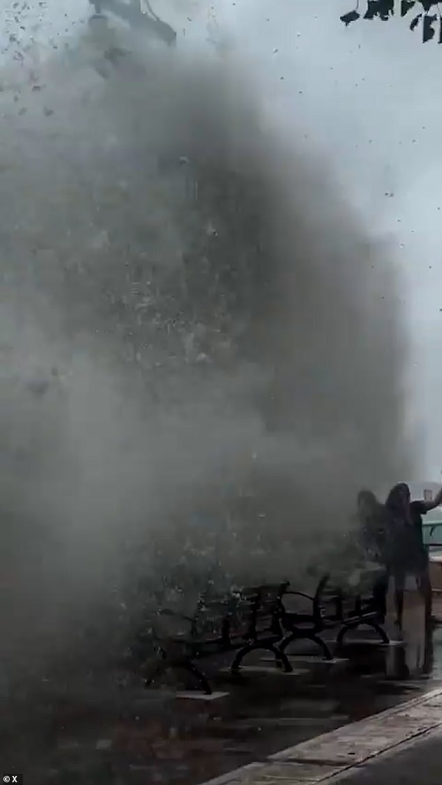 The video, taken in the South Horizons district of Hong Kong , showed the trio cautiously stepping away from the sea front as a powerful, enormous wave rises high above them