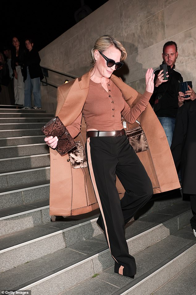 Robin waved to fans and photographers as she left the runway show