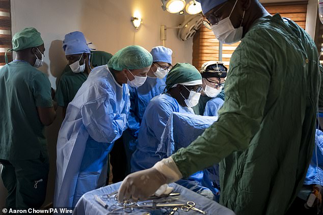 The Duchess of Edinburgh watches Dr Denis Mukwege perform surgery on a child survivor of rape at the Panzi Clinic in Kinshasa