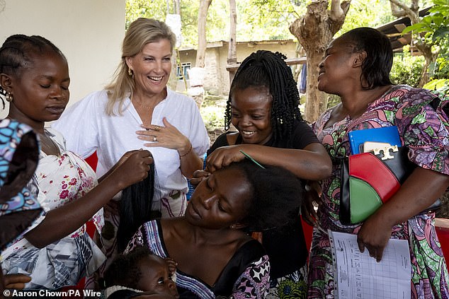 The Duchess of Edinburgh watches a woman teach how to apply hair extensions and braids at a women's safe space on Tuesday