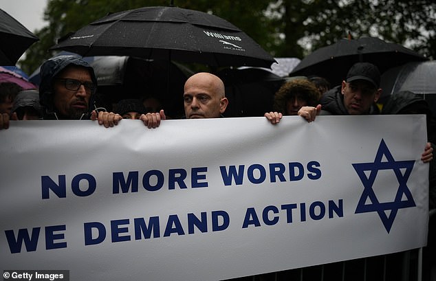 Attendees held a banner reading 'No more words, we demand action' during Friday's vigil