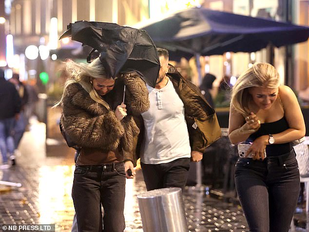 Strong winds up to 100mph were recorded across the UK. Pictured: Revellers face stormy weather on a night out in Leeds on Friday