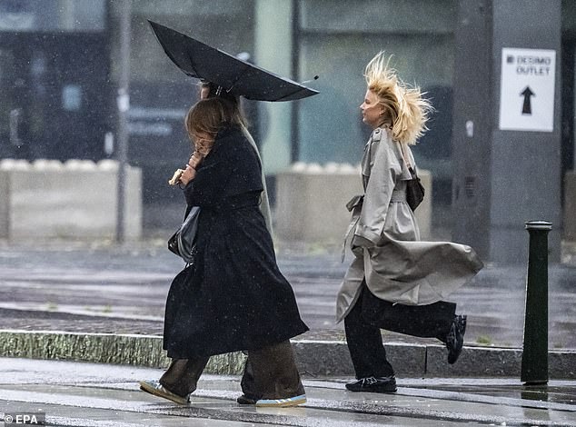 People were spotted struggling against the severe wind and rain in Malmo, Sweden
