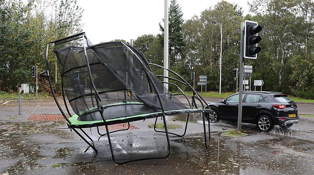 A trampoline, battered and mangled by the storm, has blown away from the nearest houses almost 100 metres away and close to a main road in Inverness, Scotland